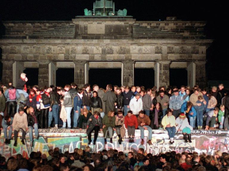 Jubelnde Menschen auf der Berliner Mauer am Brandenburger Tor am 10.11.1989. Am Abend des 09.11.1989 teilte SED-Politbüro Mitglied Günter Schabowski mit, daß alle DDR-Grenzen in die Bundesrepublik und nach West-Berlin für DDR-Bürger geöffnet werden.
