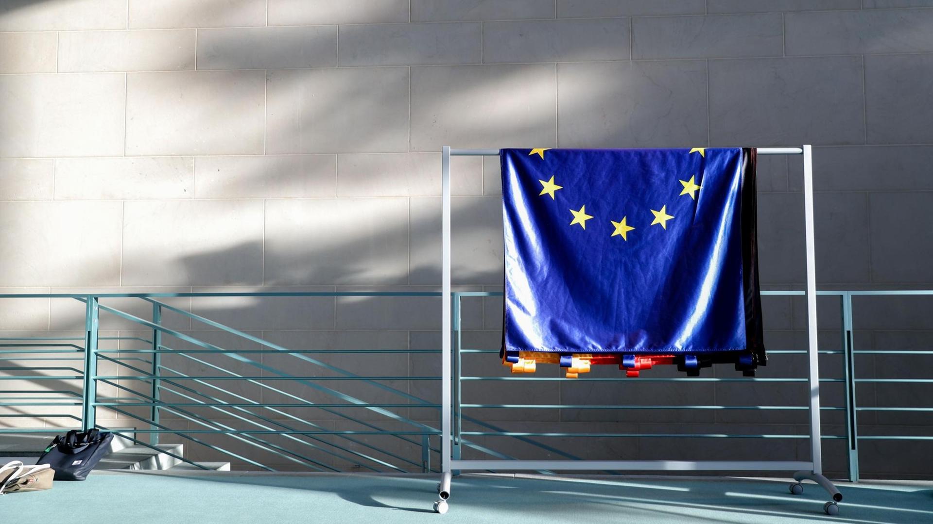 Eine EU-Flagge hängt über einem Geländer. Eine EU-Flagge hängt über einem Geländer.