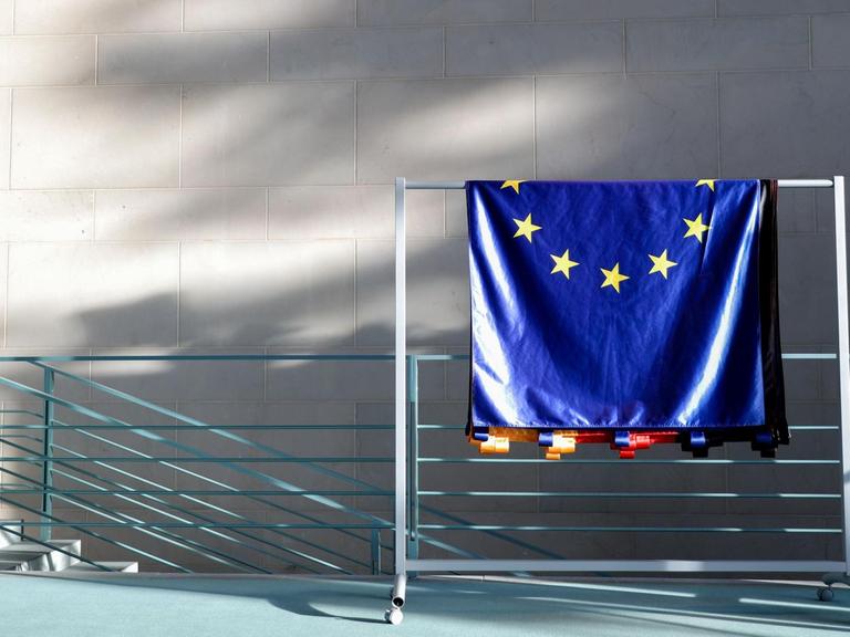 Eine EU-Flagge hängt über einem Geländer.