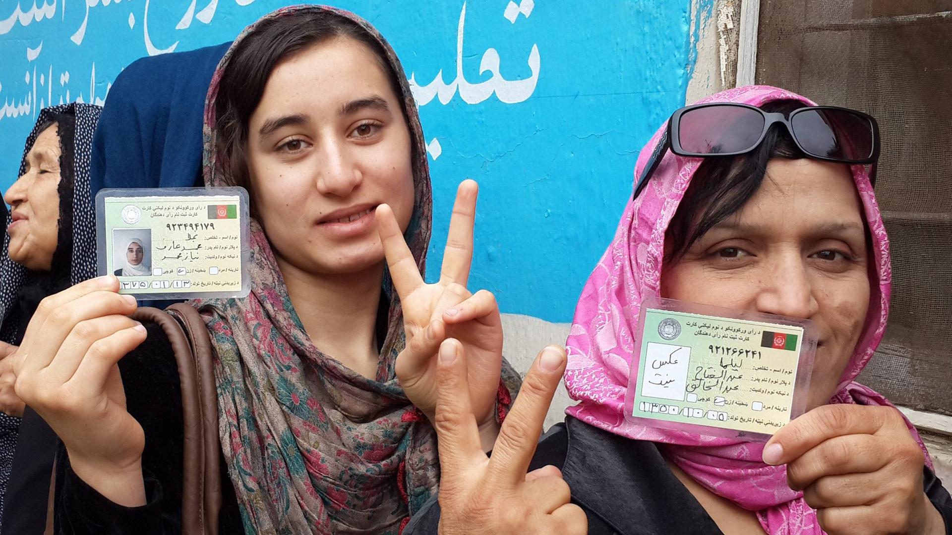 Frauen, die 2014 bei der Präsidentschaftswahl in Afghanistan ihre Stimme abgeben. Unter Taliban-Herrschaft undenkbar. Sie zeigen das Victory-Zeichen. Frauen, die 2014 bei der Präsidentschaftswahl in Afghanistan ihre Stimme abgeben. Unter Taliban-Herrschaft undenkbar. Sie zeigen das Victory-Zeichen.