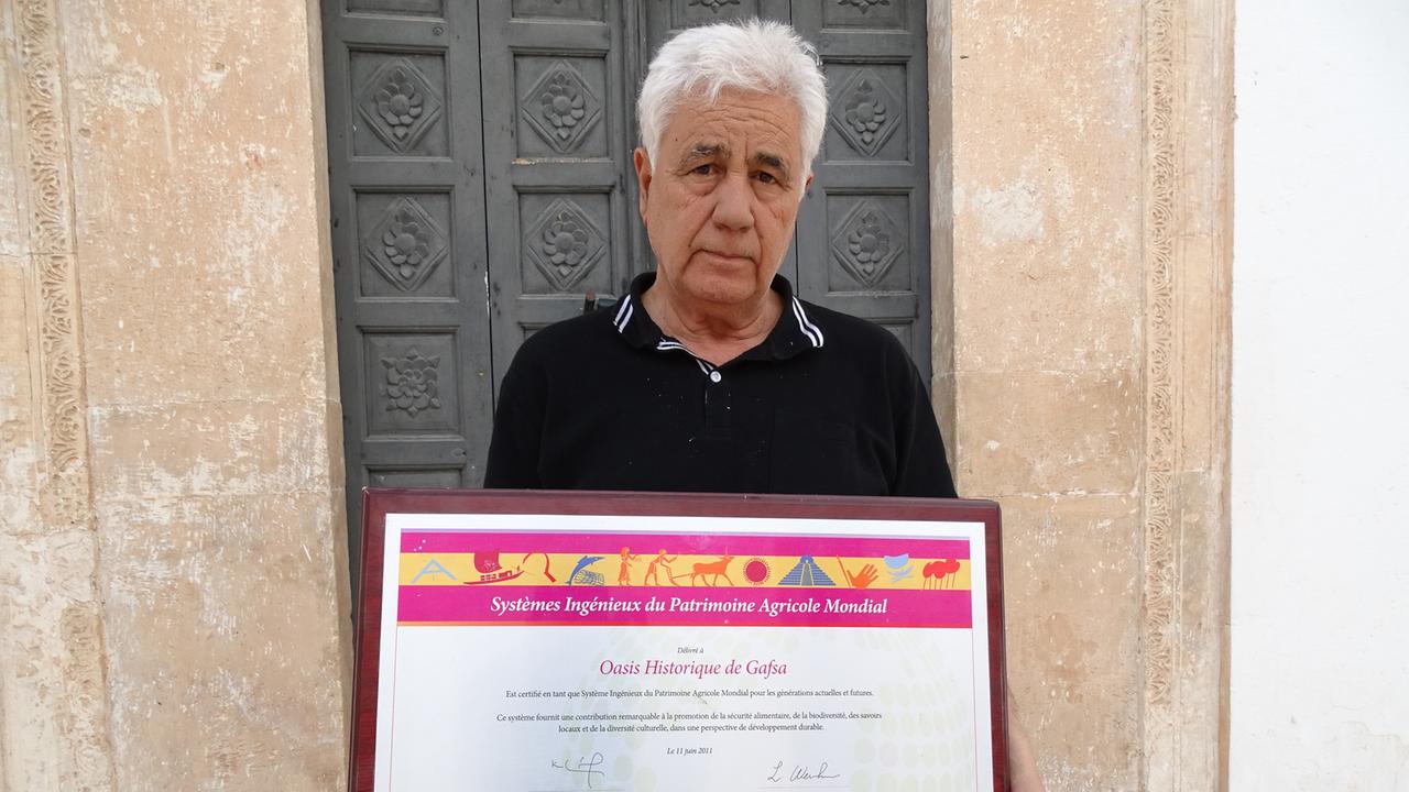 Lahzar Cherif: Präsident der ASM Gafsa - Association pour le Sauvegarde de la Médina de Gafsa. Cherif und sein Team sind enge Partner der FAO und sozusagen Durchführungsorganisation beim Schutz der Oase von Gafsa als Weltagrarkulturerbe. Hier hält Cherif stolz die Urkunde in Händen.