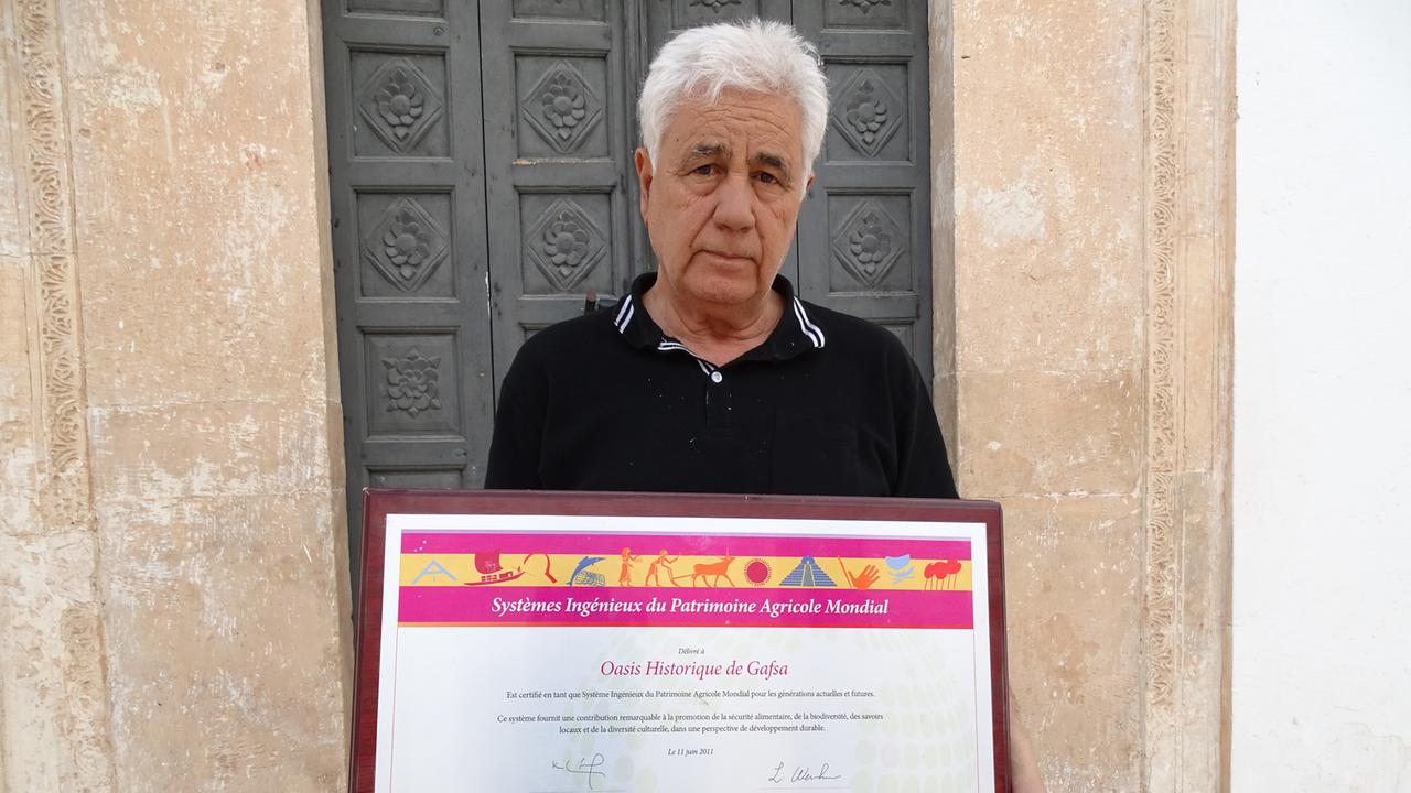Lahzar Cherif: Präsident der ASM Gafsa - Association pour le Sauvegarde de la Médina de Gafsa. Cherif und sein Team sind enge Partner der FAO und sozusagen Durchführungsorganisation beim Schutz der Oase von Gafsa als Weltagrarkulturerbe. Hier hält Cherif stolz die Urkunde in Händen. Lahzar Cherif: Präsident der ASM Gafsa - Association pour le Sauvegarde de la Médina de Gafsa. Cherif und sein Team sind enge Partner der FAO und sozusagen Durchführungsorganisation beim Schutz der Oase von Gafsa als Weltagrarkulturerbe. Hier hält Cherif stolz die Urkunde in Händen.
