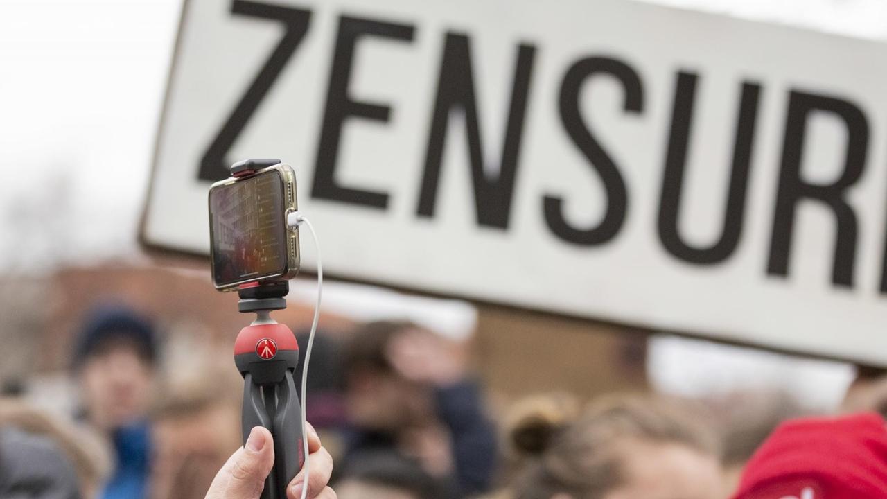 Zensur ist bei einer Demonstration des Bündnisses «Berlin gegen 13» gegen Uploadfilter und EU-Urheberrechtsreform im Artikel 13 auf einem Plakat zu lesen, während ein Teilnehmer mit einem Handy filmt. 