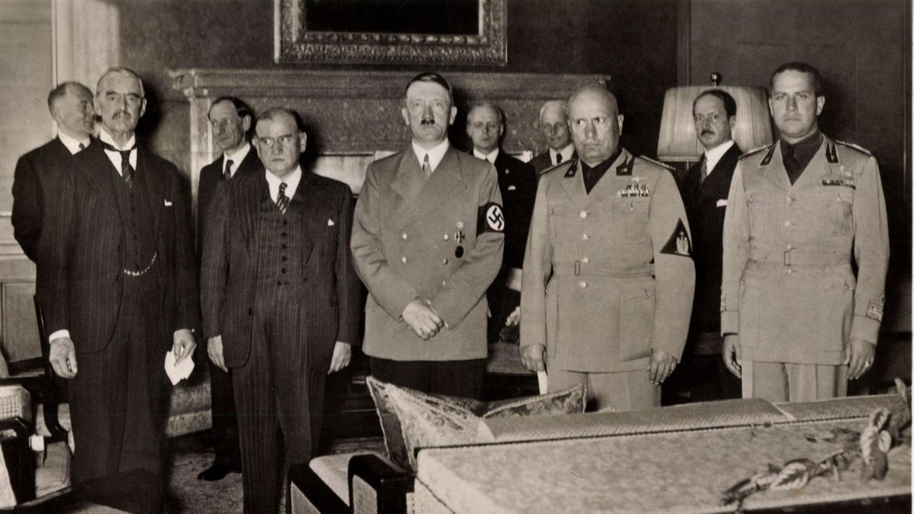 Historische Aufnahme von 1938: Die Politiker Chamberlain, Daladier, Hitler, Mussolini und Galeazzo Ciano stehen in einer Reihe nebeneinander. Historische Aufnahme von 1938: Die Politiker Chamberlain, Daladier, Hitler, Mussolini und Galeazzo Ciano stehen in einer Reihe nebeneinander.