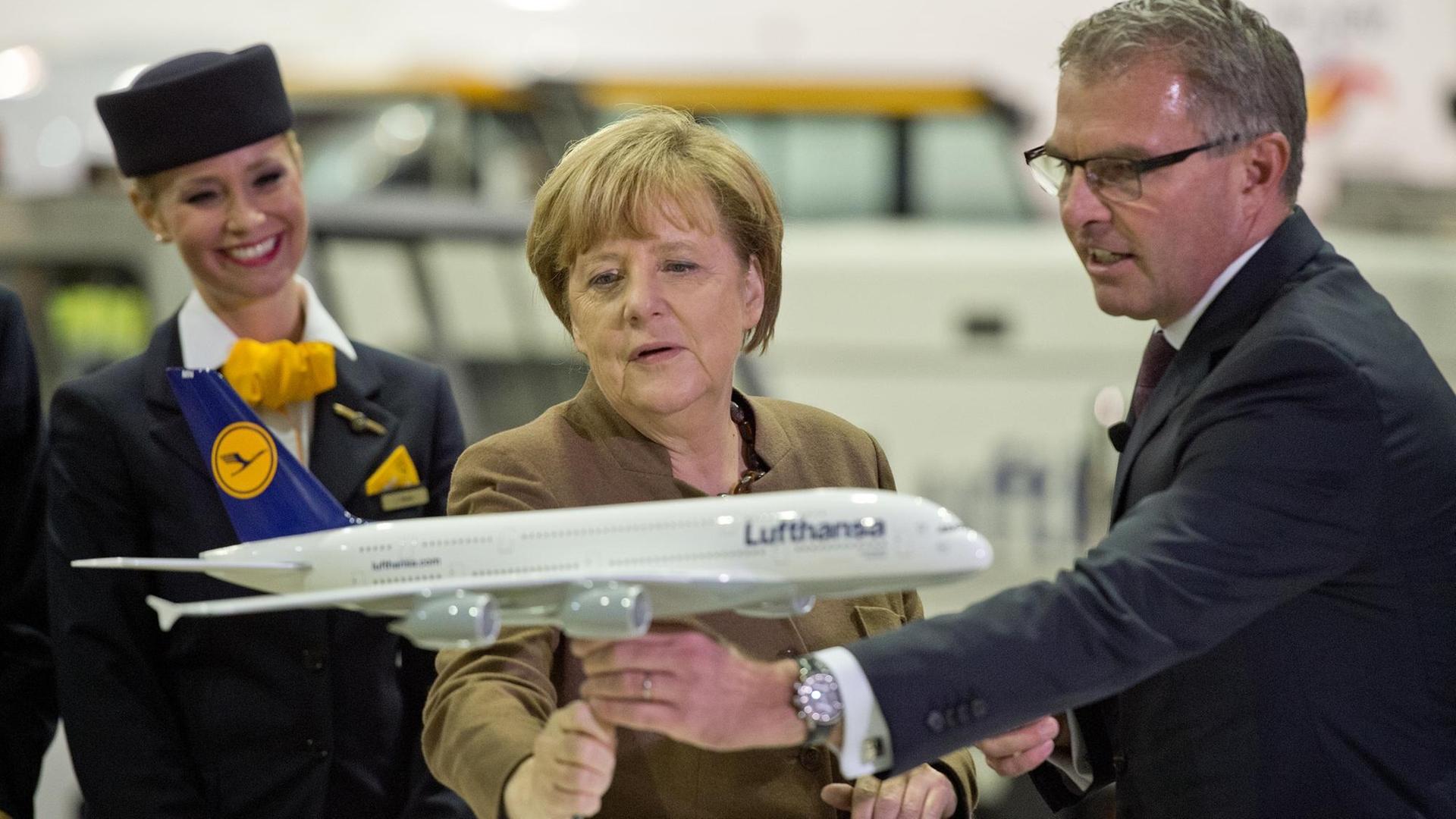 Bundeskanzlerin Angela Merkel (CDU) besucht am 18.11.2015 die Lufthansa in Frankfurt am Main (Hessen). Dabei nimmt Sie zusammen mit Lufthansa-Chef Carsten Spohr das Modell eines Airbus A380-800 in die Hand. Foto: Boris Roessler/dpa | Verwendung weltweit Bundeskanzlerin Angela Merkel (CDU) besucht am 18.11.2015 die Lufthansa in Frankfurt am Main (Hessen). Dabei nimmt Sie zusammen mit Lufthansa-Chef Carsten Spohr das Modell eines Airbus A380-800 in die Hand. Foto: Boris Roessler/dpa | Verwendung weltweit