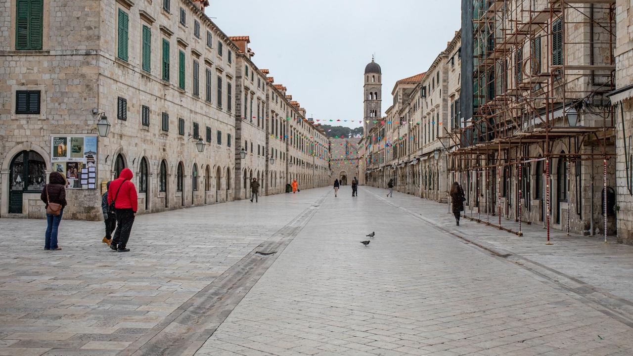 Einige Passanten gehen durch die Altstadt von Dubrovnik.