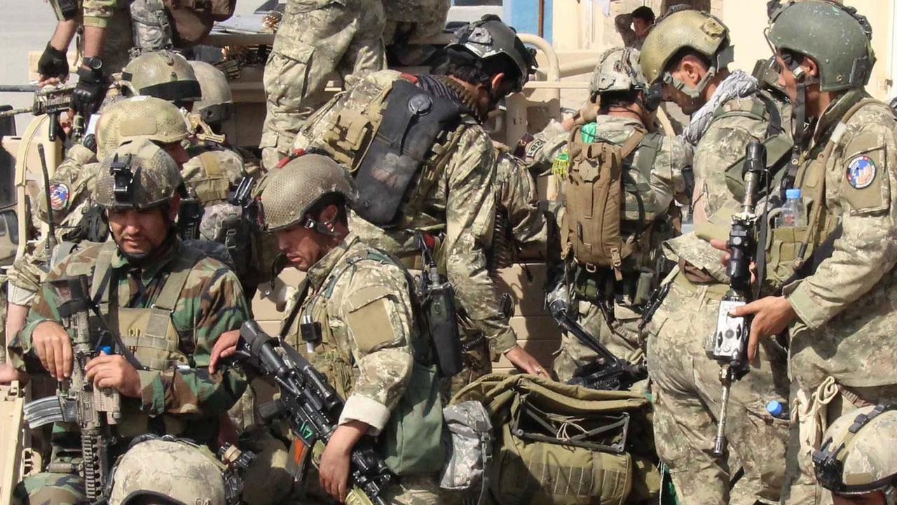 Das Bild zeigt viele schwerbewaffnete Soldaten in Tarnuniformen und Helmen auf bzw. vor der Ladefläche eines Militär-Lastwagens. Das Bild zeigt viele schwerbewaffnete Soldaten in Tarnuniformen und Helmen auf bzw. vor der Ladefläche eines Militär-Lastwagens.