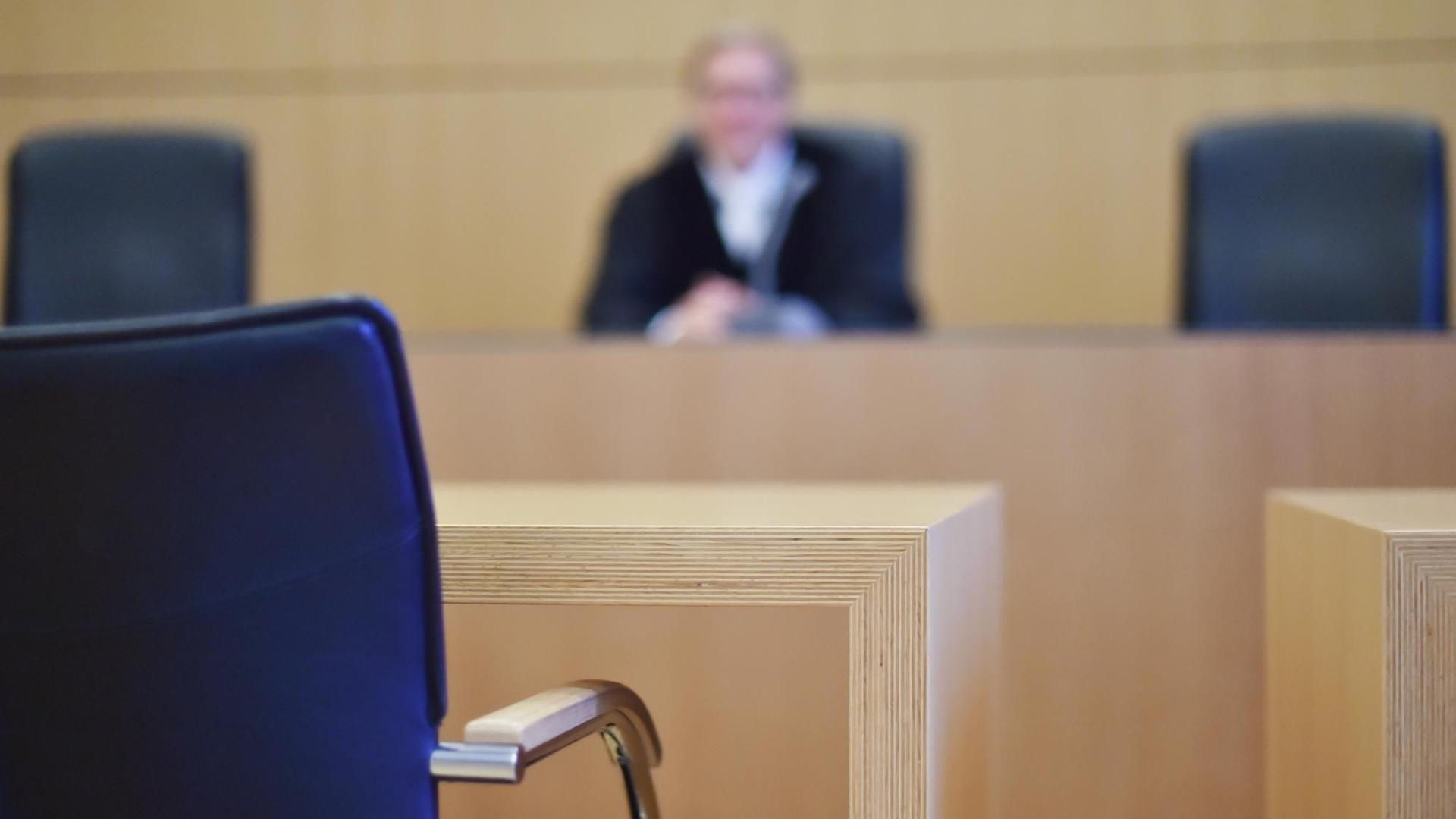 In einem Sitzungssaal beim Oberlandesgericht Karlsruhe sitzt ein Richter mit Richterrobe.