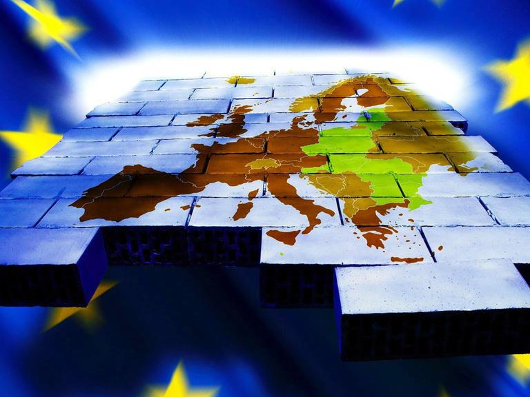 Eine Landkarte der EU-Mitgliedsländer auf einer Wand aus Bausteinen, umrahmt von der EU-Flagge.