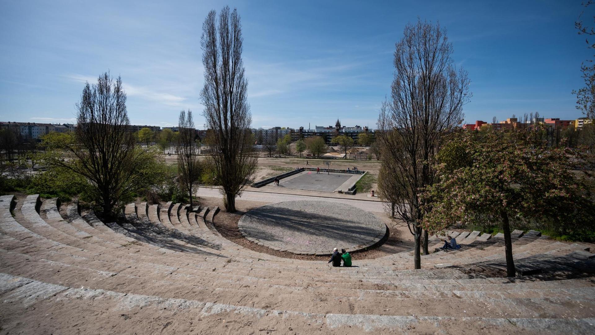 Zwei Menschen sitzen im sonst leeren Amphitheater des Mauerpark in Berlin Prenzlauer-Berg. Zwei Menschen sitzen im sonst leeren Amphitheater des Mauerpark in Berlin Prenzlauer-Berg.