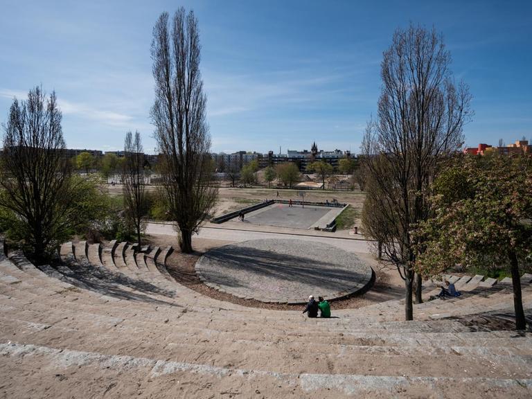 Zwei Menschen sitzen im sonst leeren Amphitheater des Mauerpark in Berlin Prenzlauer-Berg.