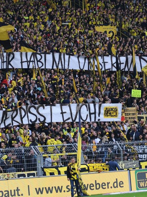 Dortmunds Fans zeigen ein Transparent mit der Aufschrift "@Die Rechte: ihr habt mit unserem Derby nichts zu tun, verpisst Euch". 