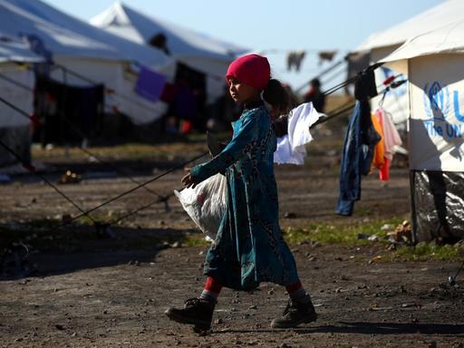 Ein Flüchtlingsmädchen mit Plastiktüte geht durch ein UN-Camp in Syrien.