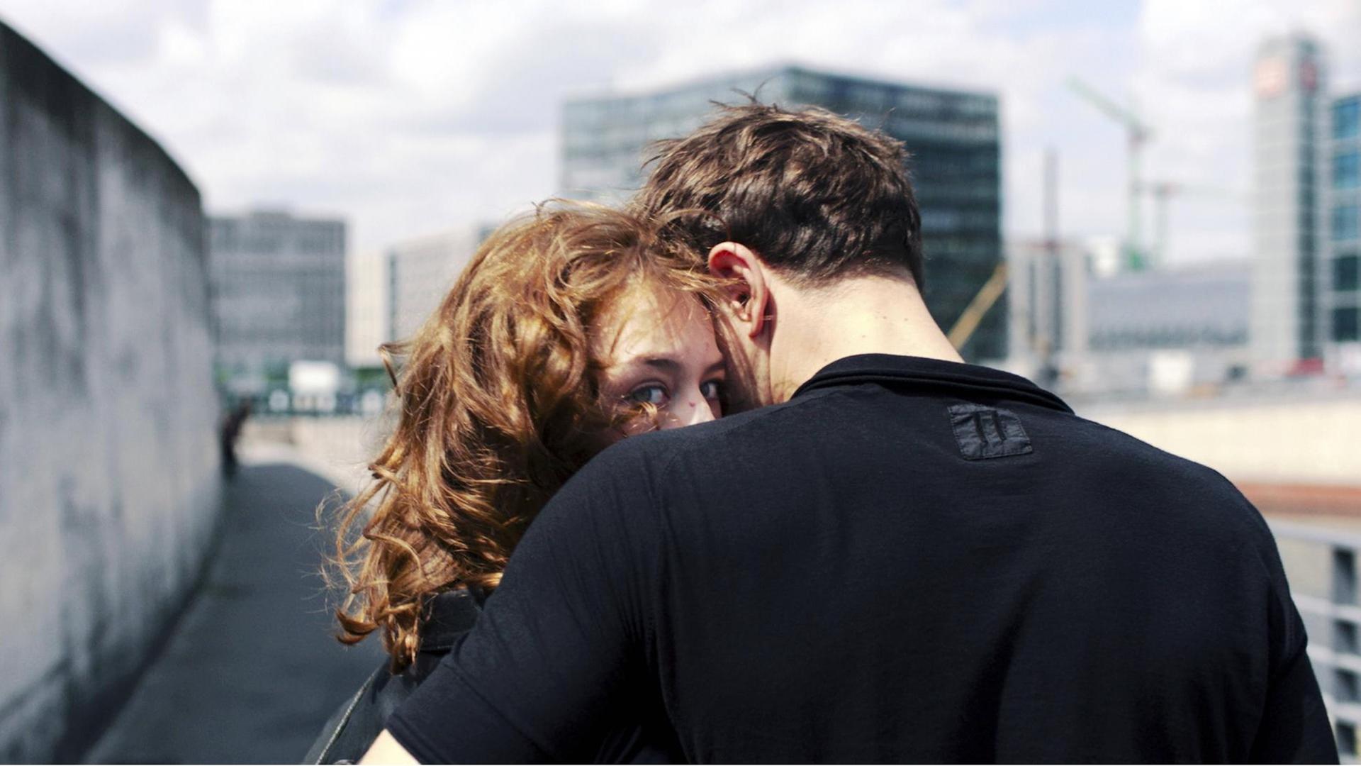 Filmstill aus Christian Petzolds Film "Undine": Ein Mann umarmt eine Frau an einer Mauer. Sie blickt in die Kamera, er in die andere Richtung. Filmstill aus Christian Petzolds Film "Undine": Ein Mann umarmt eine Frau an einer Mauer. Sie blickt in die Kamera, er in die andere Richtung.