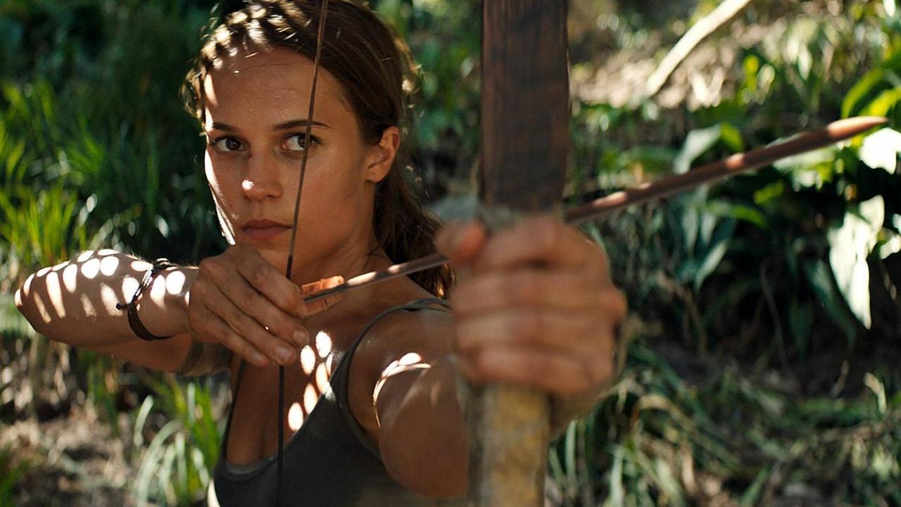Alicia Vikander als Lara Croft in "Tomb Raider", sie ist von vorne zu sehen, schaut konzentriert und spannt einen Bogen Alicia Vikander als Lara Croft in "Tomb Raider", sie ist von vorne zu sehen, schaut konzentriert und spannt einen Bogen