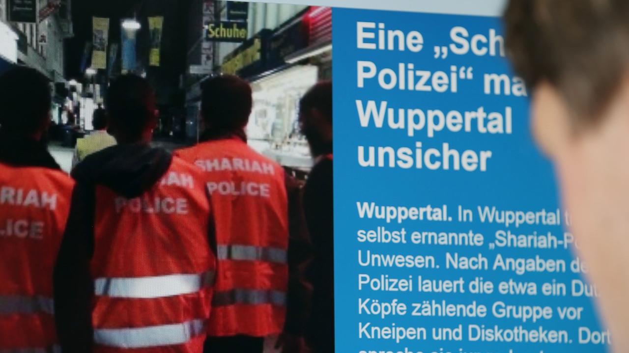 Ein Mann blickt auf einen Computer-Bildschirm, auf dem selbsternannte "Scharia-Polizisten" zu sehen sind. Ein Mann blickt auf einen Computer-Bildschirm, auf dem selbsternannte "Scharia-Polizisten" zu sehen sind.