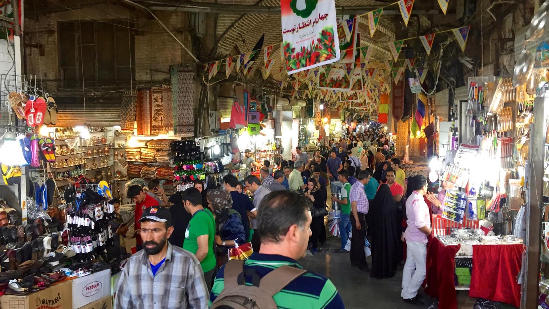 Sie sehen viele Menschen am Haupteingang des Basars von Teheran. Sie sehen viele Menschen am Haupteingang des Basars von Teheran.