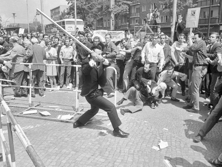 Beim Staatsbesuch des persischen Schah demonstrieren Berliner Studenten 1967 gegen das repressive Regime des Herrschers. Vor dem Rathaus in Schöneberg kommt es am 2. Juni zu Ausschreitungen zwischen Demonstranten, Schah-Anhängern und der Polizei.