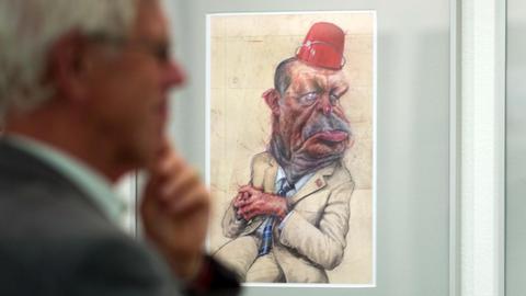 Ein Besucher betrachtet die Karikatur "Erdogan" von Frank Hoppmann.