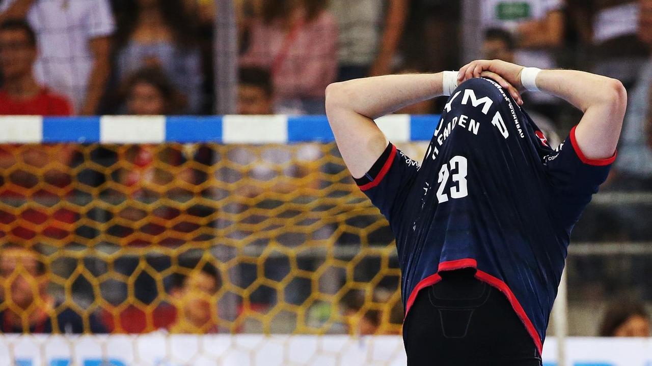 Ein Spieler des VfL Gummersbach zieht sich beim letzten Heimspiel in der Bundesliga das Trikot über den Kopf. Im Hintergrund ist ein Tor zu erkennen. Ein Spieler des VfL Gummersbach zieht sich beim letzten Heimspiel in der Bundesliga das Trikot über den Kopf. Im Hintergrund ist ein Tor zu erkennen.