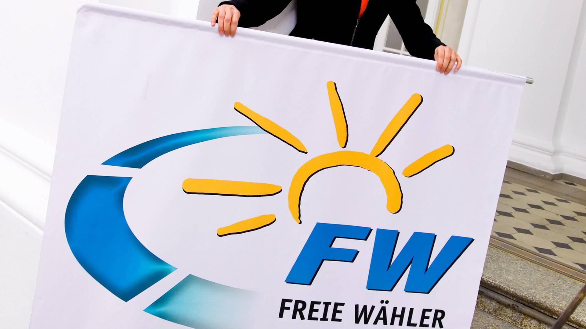 Eine Aktivistin der Freien Wähler mit einem Plakat der Partei in der Hand Eine Aktivistin der Freien Wähler mit einem Plakat der Partei in der Hand