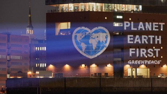 "Planet Earth First" steht durch eine Projektion auf der Elbphilharmonie in Hamburg.
