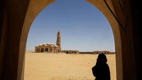 Ein koptischer Priester hält sich im Sankt Samuel Kloster in der Nähe von Minja (Ägypten) ein Radio ans Ohr.