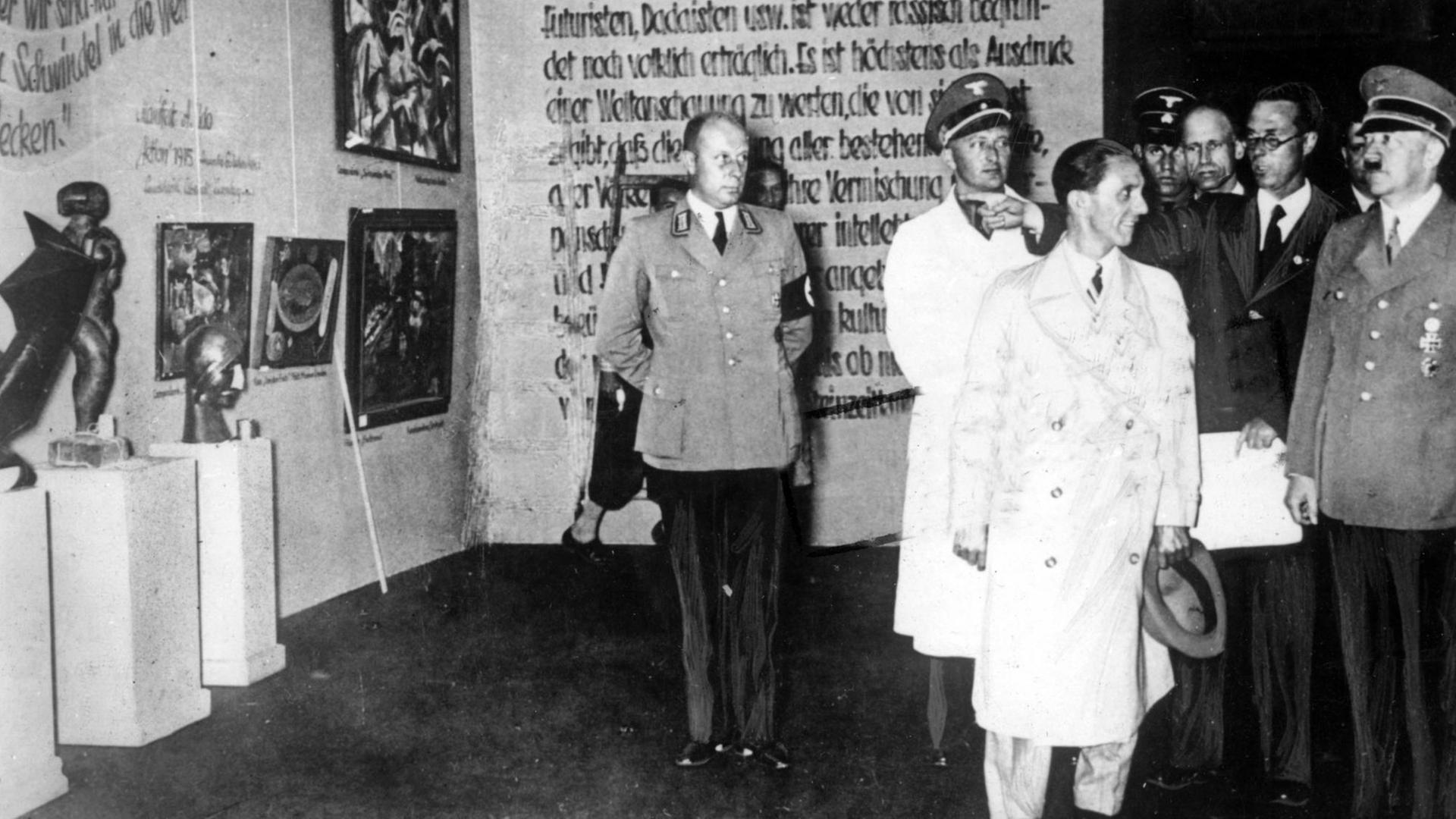 Der nationalsozialistische Führer Adolf Hitler (r) und der Reichsminister für Volksaufklärung und Propaganda, Joseph Goebbels (M), besuchen 1937 die Ausstellung "Entartete Kunst" im Münchner Haus der Kunst. Während des Dritten Reiches wurden auf der Grundlage der Rassentheorie unzählige moderne Kunstwerke von den Nationalsozialisten als "artfremd", bzw. "entartet" angesehen und beschlagnahmt oder zerstört. Eine Auswahl der Werke wurde 1937 in München ausgestellt. Der nationalsozialistische Führer Adolf Hitler (r) und der Reichsminister für Volksaufklärung und Propaganda, Joseph Goebbels (M), besuchen 1937 die Ausstellung "Entartete Kunst" im Münchner Haus der Kunst. Während des Dritten Reiches wurden auf der Grundlage der Rassentheorie unzählige moderne Kunstwerke von den Nationalsozialisten als "artfremd", bzw. "entartet" angesehen und beschlagnahmt oder zerstört. Eine Auswahl der Werke wurde 1937 in München ausgestellt.