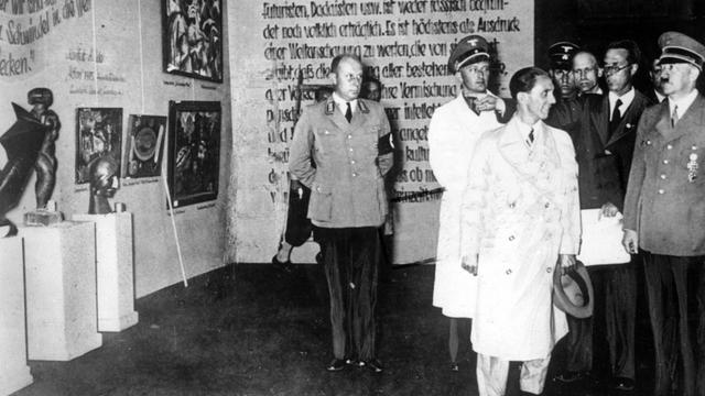Der nationalsozialistische Führer Adolf Hitler (r) und der Reichsminister für Volksaufklärung und Propaganda, Joseph Goebbels (M), besuchen 1937 die Ausstellung "Entartete Kunst" im Münchner Haus der Kunst. Während des Dritten Reiches wurden auf der Grund