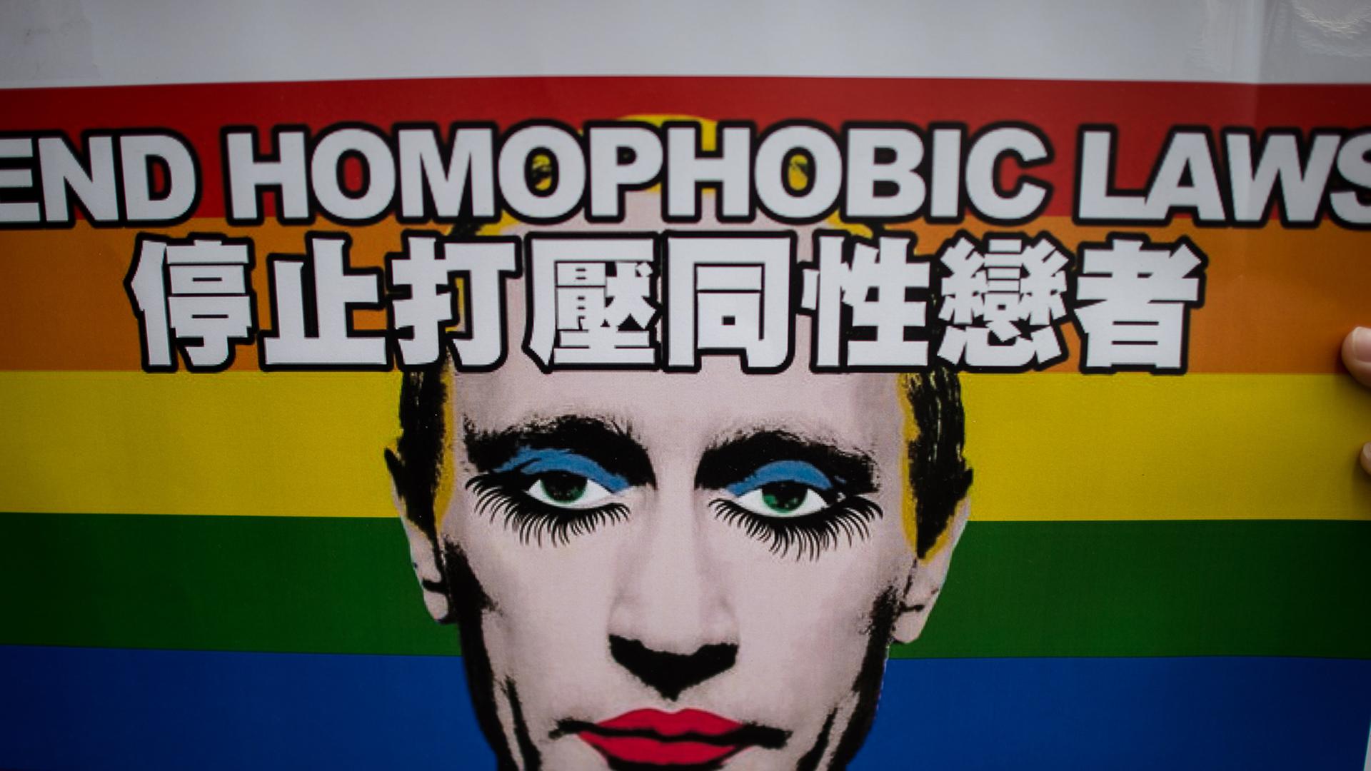 Ein Plakat mit der Aufschrift "End homophobic laws" zeigt einen wie eine Dragqueen geschminkten Wladimir Putin, im Hintergrund die Regenbogenflagge als Symbol der homosexuellen Bewegung. Ein Plakat mit der Aufschrift "End homophobic laws" zeigt einen wie eine Dragqueen geschminkten Wladimir Putin, im Hintergrund die Regenbogenflagge als Symbol der homosexuellen Bewegung.