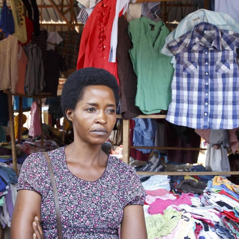 Eine Strassenhaendlerin verkauft gebrauchte Kleidungsstuecke in der Markthalle von Kigali.