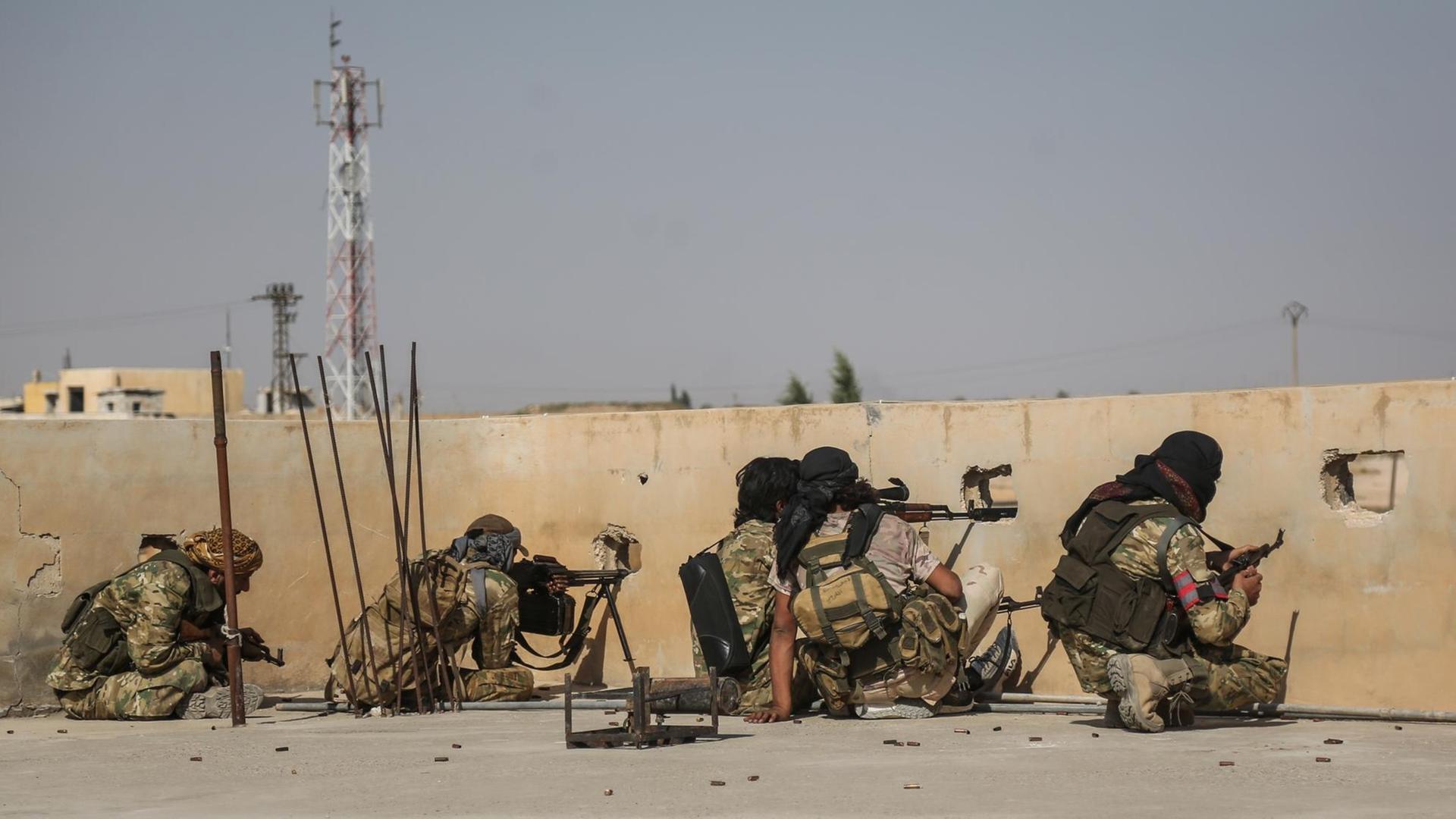 Scharfschützen der türkisch unterstützten syrischen Nationalarmee schießen bei einem Zusammenstoß mit kurdischen Kämpfern von einem Dach Scharfschützen der türkisch unterstützten syrischen Nationalarmee schießen bei einem Zusammenstoß mit kurdischen Kämpfern von einem Dach