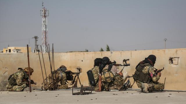 Scharfschützen der türkisch unterstützten syrischen Nationalarmee schießen bei einem Zusammenstoß mit kurdischen Kämpfern von einem Dach