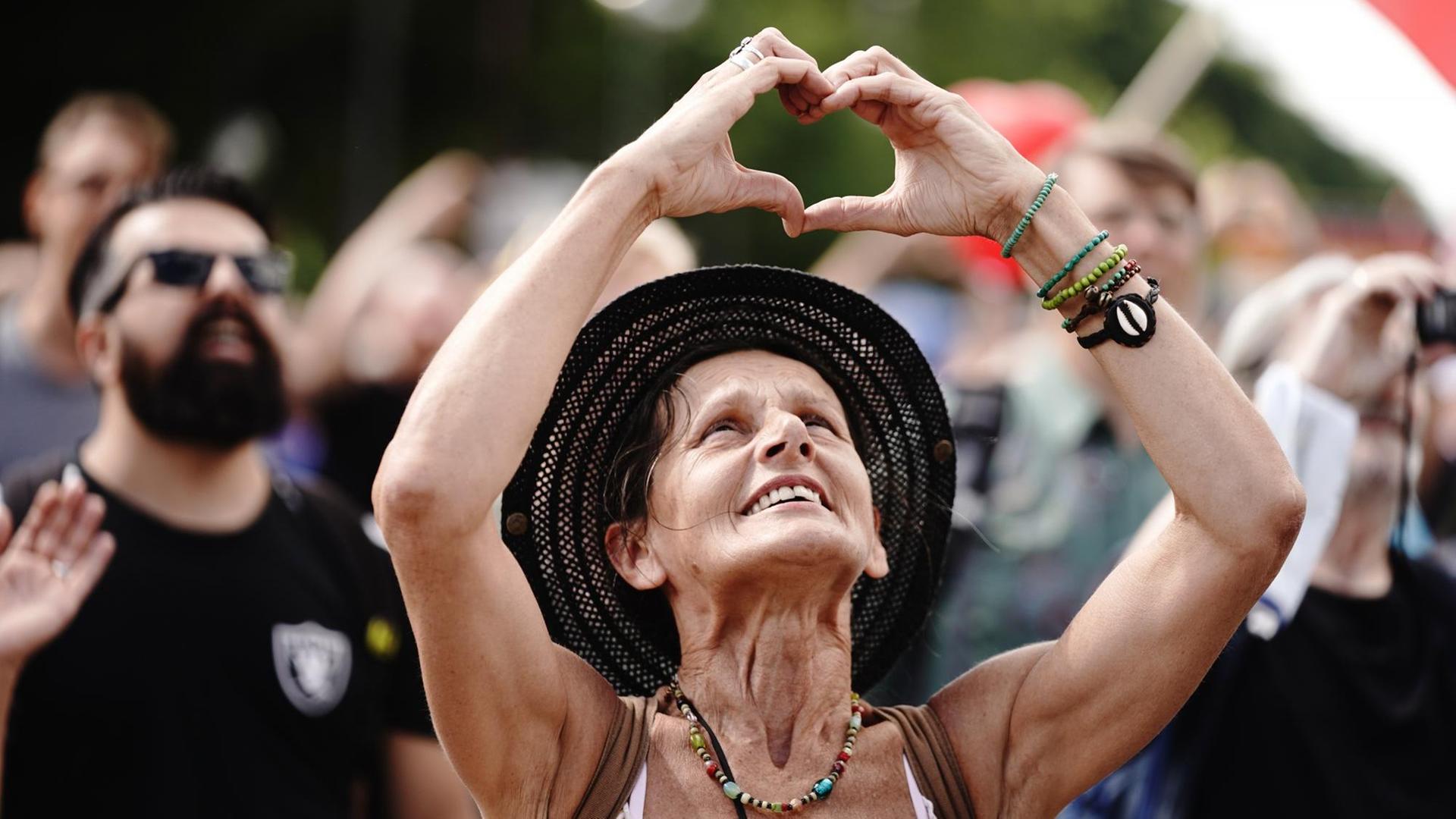 Eine Teilnehmerin formt ein Herz mit den Händen bei einer Demonstration gegen die Corona-Maßnahmen. Eine Teilnehmerin formt ein Herz mit den Händen bei einer Demonstration gegen die Corona-Maßnahmen.