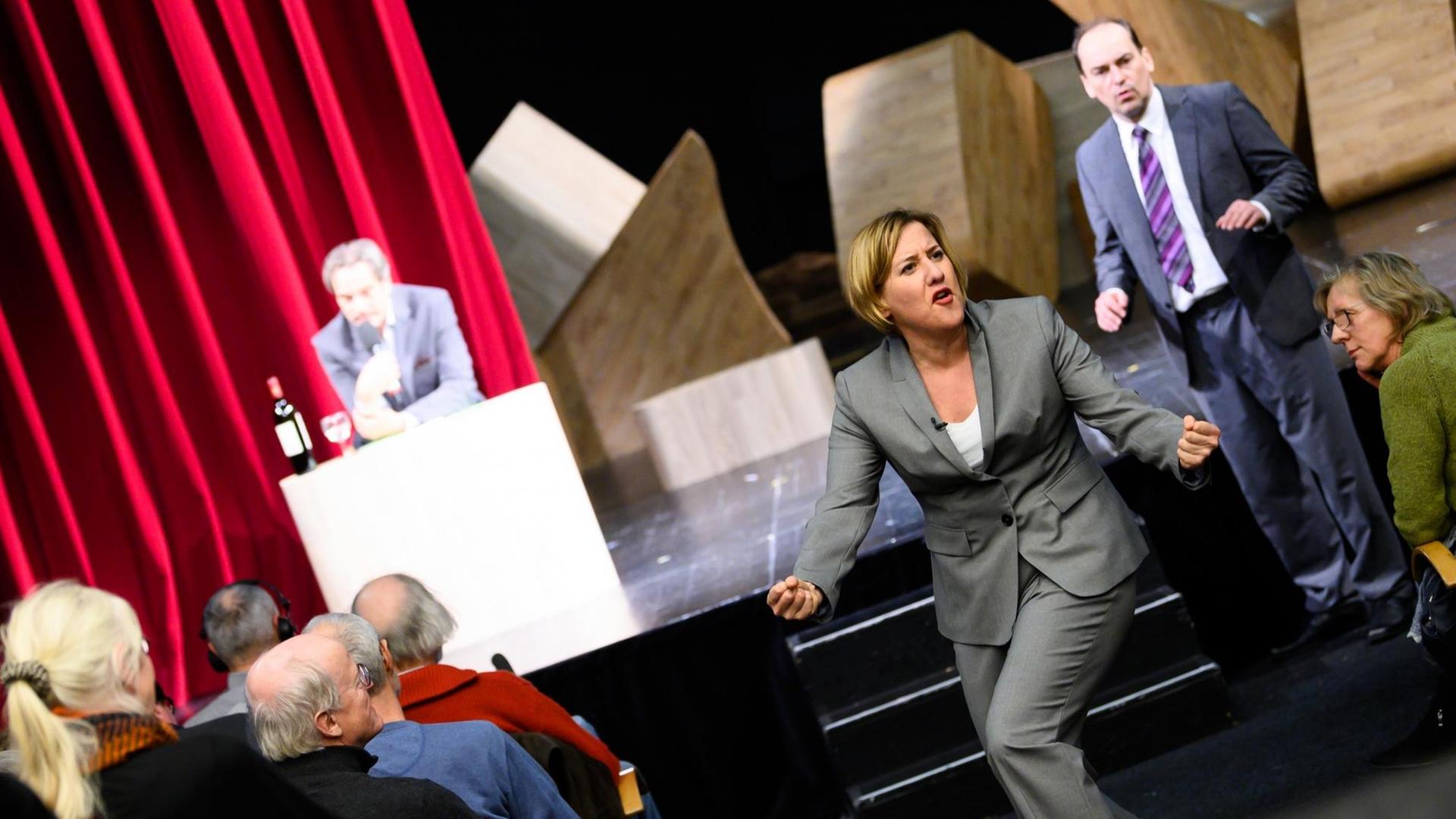 19.02.2019, Bremen: Silke Buchholz in der Rolle von Angela Merkel in der Zeit nach ihrer Kanzlerschaft und Markus Seuß (r) in der Rolle ihres ehemaligen Fahrers treten während der Theaterprobe bei der Bremer Shakespear Company auf. Die Uraufführung des Stücks "Angela I." soll am 28.02.2019 stattfinden. (zu dpa "Theaterstück «Angela I.» katapultiert Nach-Merkel-Ära ins Jetzt") Foto: Mohssen Assanimoghaddam/dpa | Verwendung weltweit 19.02.2019, Bremen: Silke Buchholz in der Rolle von Angela Merkel in der Zeit nach ihrer Kanzlerschaft und Markus Seuß (r) in der Rolle ihres ehemaligen Fahrers treten während der Theaterprobe bei der Bremer Shakespear Company auf. Die Uraufführung des Stücks "Angela I." soll am 28.02.2019 stattfinden. (zu dpa "Theaterstück «Angela I.» katapultiert Nach-Merkel-Ära ins Jetzt") Foto: Mohssen Assanimoghaddam/dpa | Verwendung weltweit