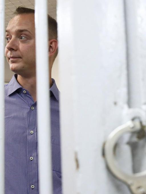 Der ehemalige russische Journalist Ivan Safronow steht bei einer Anhörung hinter Gitterstäben.
