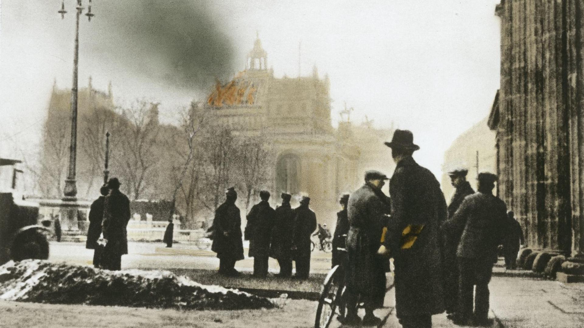Aufnahme aus dem Februar 1933 im Vordergrund sind Menschen zu sehen, die auf dem im Hintergrund liegenden Reichstag in Berlin blicken, der brennt. Aufnahme aus dem Februar 1933 im Vordergrund sind Menschen zu sehen, die auf dem im Hintergrund liegenden Reichstag in Berlin blicken, der brennt.