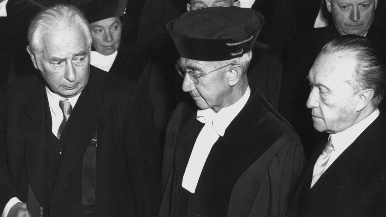 Bundespräsident Theodor Heuss (l-r), der erste Präsident des Bundesverfassungsgerichts, Dr. Hermann Höpker-Aschoff und Bundeskanzler Konrad Adenauer während der Feierstunde zur Eröffnung des Bundesverfassungsgerichts am 28. September 1951 im Kleinen Haus des Badischen Staatstheaters in Karlsruhe. Bundespräsident Theodor Heuss (l-r), der erste Präsident des Bundesverfassungsgerichts, Dr. Hermann Höpker-Aschoff und Bundeskanzler Konrad Adenauer während der Feierstunde zur Eröffnung des Bundesverfassungsgerichts am 28. September 1951 im Kleinen Haus des Badischen Staatstheaters in Karlsruhe.