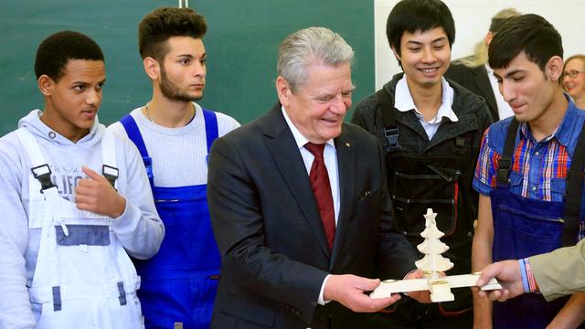 Der Bundespräsident Joachim Gauck (M) unterhält sich am 12.12.2014 in Magdeburg (Sachsen-Anhalt) mit den minderjährigen Flüchtlingen Merhawi (l-r) aus Eritrea, den Serben Aleksandar (l-r), Merhawi aus Eritrea und Luan aus Vietnam sowie den Afghanen Amin.