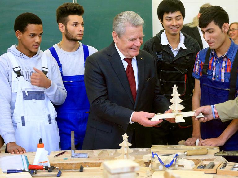 Der Bundespräsident Joachim Gauck (M) unterhält sich am 12.12.2014 in Magdeburg (Sachsen-Anhalt) mit den minderjährigen Flüchtlingen Merhawi (l-r) aus Eritrea, den Serben Aleksandar (l-r), Merhawi aus Eritrea und Luan aus Vietnam sowie den Afghanen Amin.