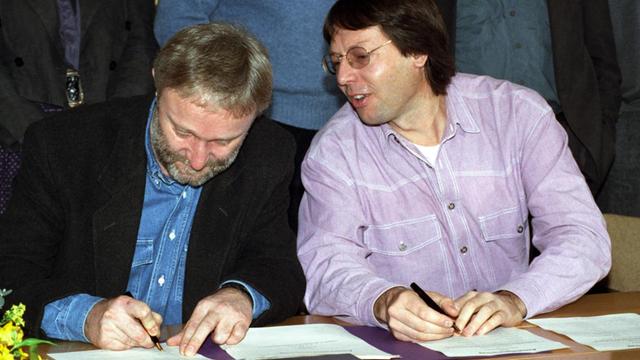 Werner Schulz (l, Bündnis 90 - Ostdeutschland) und Ludger Vollmer (r, Grüne - Westdeutschland) unterzeichnen am 23.11.1992 in Bonn bei der Unterzeichnung des Assoziationsvertrags über den Zusammenschluss der Parteien. Der Name der neuen Partei - Bündnis 90 Die Grünen - war zu dem Zeitpunkt noch umstritten