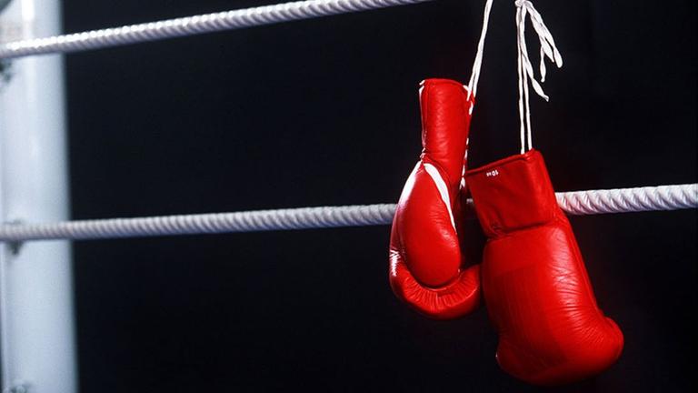 Box-Handschuhe hängen über ein Seil von einem Box-Ring. Box-Handschuhe hängen über ein Seil von einem Box-Ring.