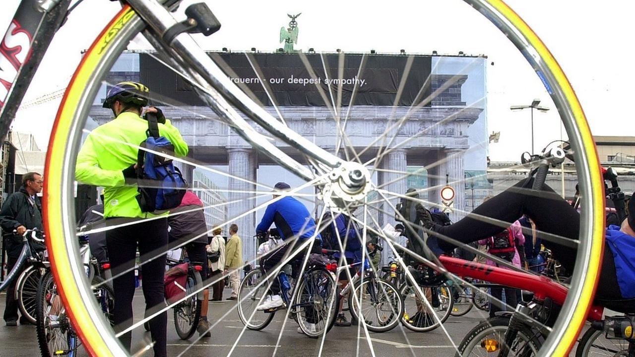 Durch das Vorderrad eines Rennrades ist das Brandenburger Tor in Berlin zu sehen. Durch das Vorderrad eines Rennrades ist das Brandenburger Tor in Berlin zu sehen.