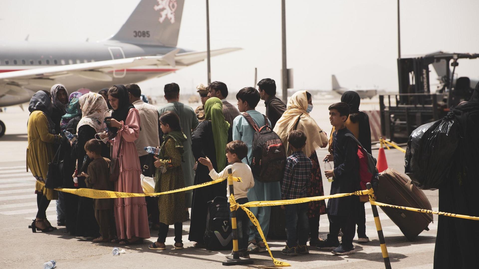 Auf einem vom U.S. Marine Corps zur Verfügung gestellten Foto bereiten sich Zivilisten während einer Evakuierung am Hamid Karzai International Airport am 18. August 2021 darauf vor, ein Flugzeug zu besteigen. Auf einem vom U.S. Marine Corps zur Verfügung gestellten Foto bereiten sich Zivilisten während einer Evakuierung am Hamid Karzai International Airport am 18. August 2021 darauf vor, ein Flugzeug zu besteigen.