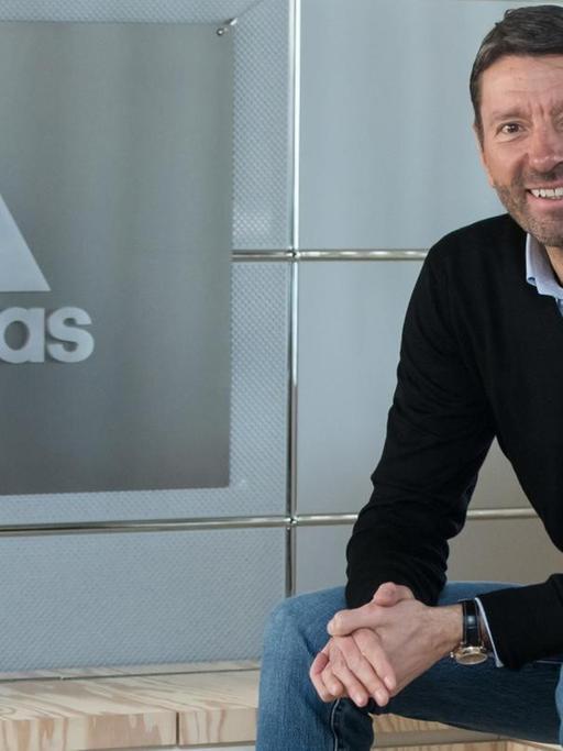 Der Vorstandsvorsitzende des Sportartikelherstellers Adidas, Kasper Rorsted, aufgenommen neben einem Firmenlogo vor der Bilanz-Pressekonferenz des Unternehmens im März 2017.