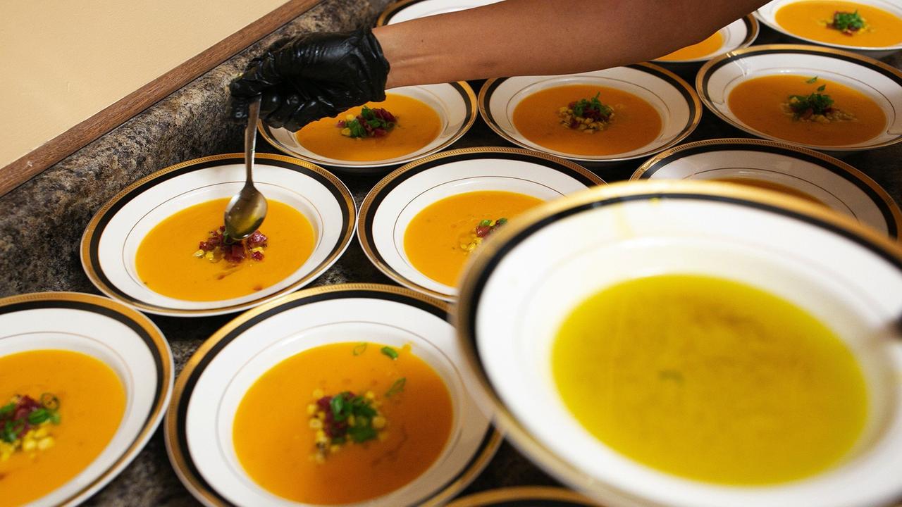 Teller mit orangefarbener Süßkartoffelsuppe in einem Restaurant (Marijuana Supper Club) in Chicago. Über die Suppe wird Cannabisöl geträufelt. Teller mit orangefarbener Süßkartoffelsuppe in einem Restaurant (Marijuana Supper Club) in Chicago. Über die Suppe wird Cannabisöl geträufelt.