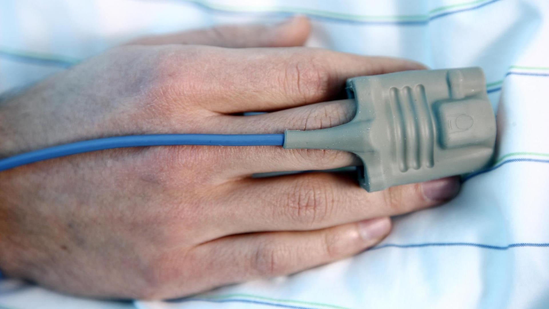 Patient mit automatischer Überwachung der Vitalfunktionen auf einer Intensivstation Patient mit automatischer Überwachung der Vitalfunktionen auf einer Intensivstation