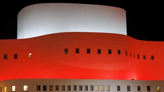 Farbig beleuchtete Fassade des Schauspielhauses in Düsseldorf bei Nacht.