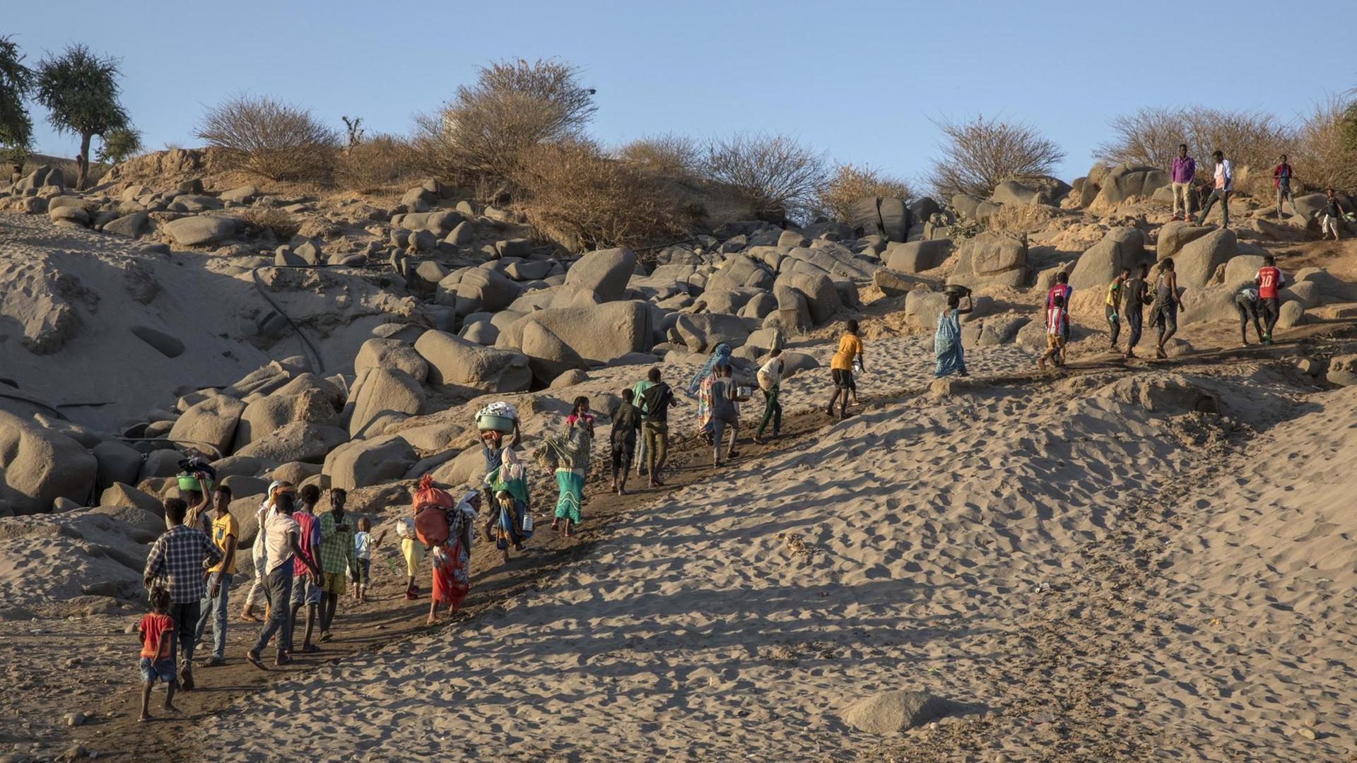 Geflüchtete aus Tigray wandern entlang eines Berges an der sudanesisch-äthiopischen Grenze in Hamdayet, im Osten Sudans, aufgenommen am 2. Dezember 2020.