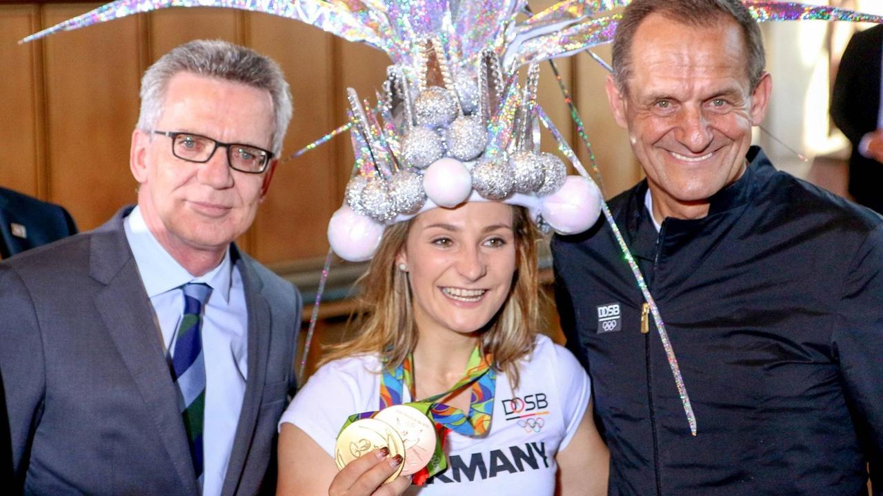 Der ehemalige Innenminister Thomas de Maiziere, Olympiagewinnerin Kristina Vogel und DOSB-Präsident Alfons Hörmann 